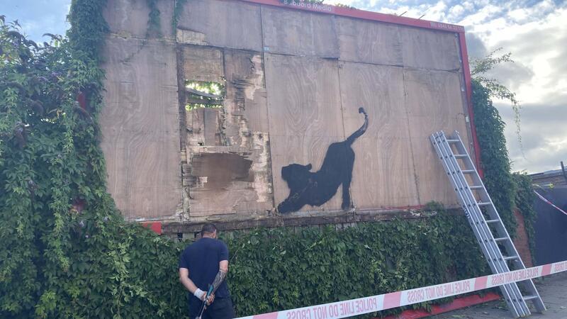 Katze bei Dehnübung: Banksy setzt Bilderreihe in London fort Die Polizei hat den Bereich um die Werbetafel mit dem Banksy-Werk abgesperrt.