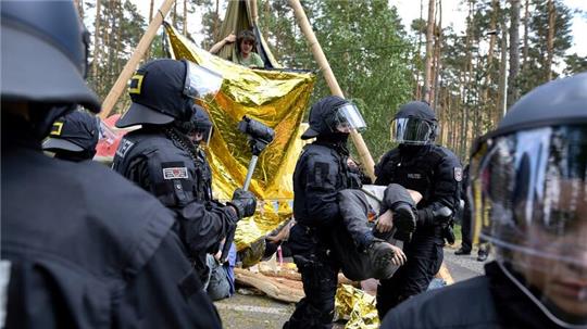 Die Polizei löst eine Straßenblockade auf.