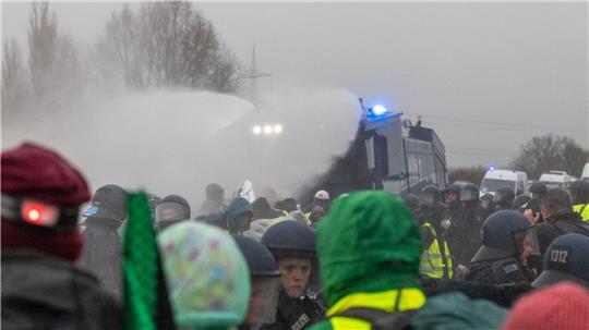 Die Polizei setzt Wasserwerfer gegen Demonstranten ein, die die B429 nahe der Lahnbrücke blockieren. 