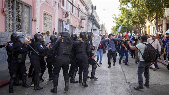Die Polizei versucht, Anhänger des gewählten guatemaltekischen Präsidenten Arévalo zurückzuhalten, die vor dem Kongress in Guatemala-Stadt gegen eine Verzögerung des Beginns der Legislaturperiode protestieren.