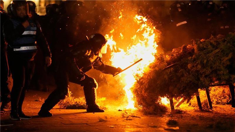 Die Polizei versucht, ein Feuer zu löschen, während Anhänger von Calin Georgescu protestieren. Die rumänische Wahlbehörde hat seine Kandidatur bei der Wiederholung der Präsidentschaftswahlen in Rumänien abgelehnt.