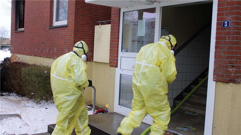 Die Polizisten betraten das Gebäude mit Schutzanzügen.