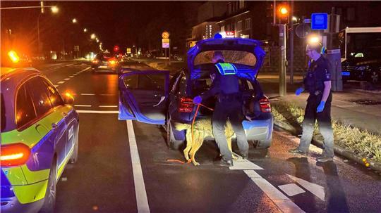 Die Polizisten durchsuchen das in Neu Wulmstorf gestoppte Fluchtfahrzeug mithilfe eines Spürhundes.