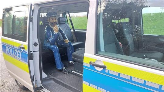 Die Polizisten laden die 30 Kilogramm schwere Figur in den Einsatzwagen.
