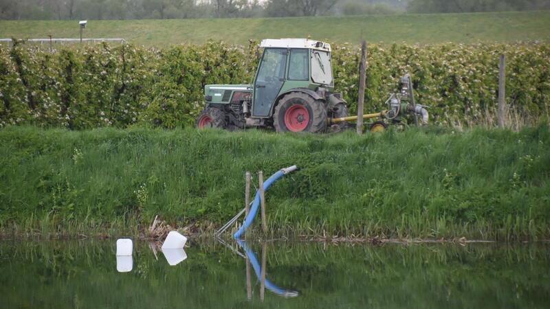 Die Pumpen werden von den Schleppern angetrieben; die Wettern, Gräben und Beregnungsteiche - wie hier an der K39 in Borstel - sind gefüllt.