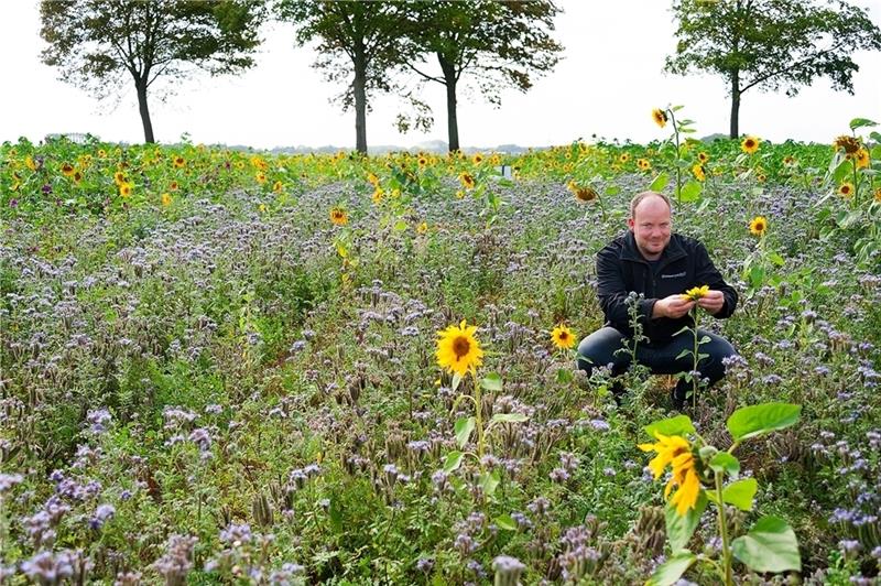 Die Raiffeisen Weser-Elbe unterstützt die Anlage von Blühwiese – auf dem Foto ist Außendienstmitarbeiter Hinnerk Witte zu sehen.