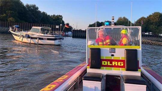 Die Retter der DLRG schleppen das manövrierunfähige Sportboot von der Elbe in den sicheren Hafen.