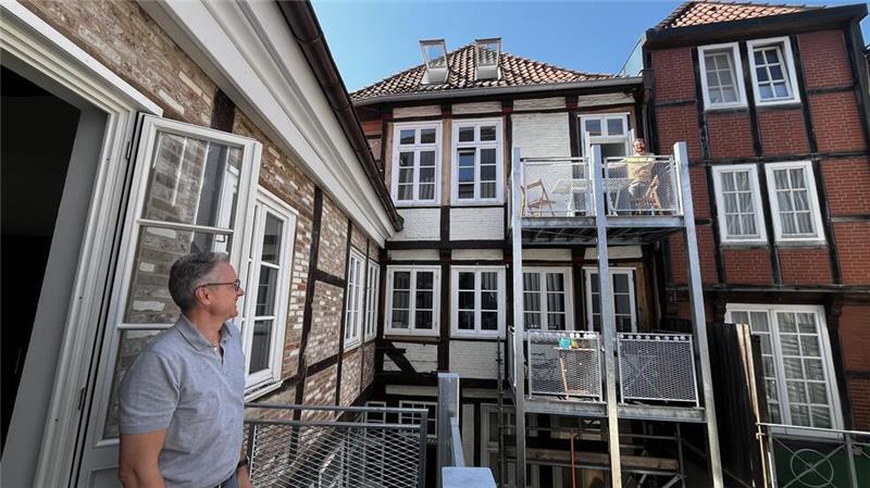Die Rückseite wird noch saniert, ist aber auch jetzt schon hübsch: Eigentümer Ulf Brokelmann und Aaron Kraska, einer der neuen Mieter, grüßen sich von Balkon zu Balkon.