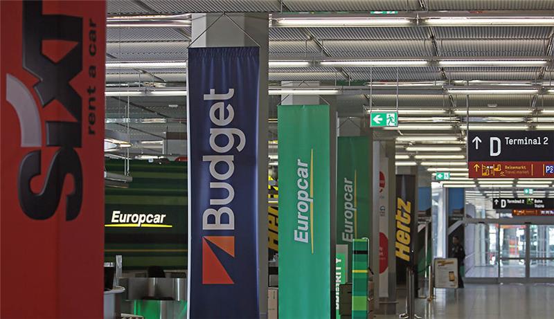 Die Schalter verschiedener Mietwagen-Anbieter sind am Flughafen Köln Bonn leer. Foto: Oliver Berg/dpa