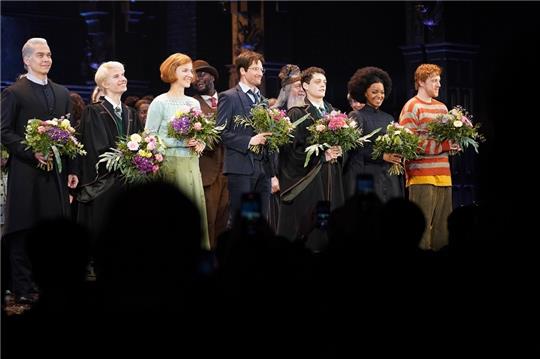 Die Schauspielerinnen und Schauspieler stehen auf der Bühne beim Schlussapplaus der Premiere der neu inszenierten Show "Harry Potter und das verwunschene Kind“ im Mehr! Theater am Großmarkt. Foto: Marcus Brandt/dpa