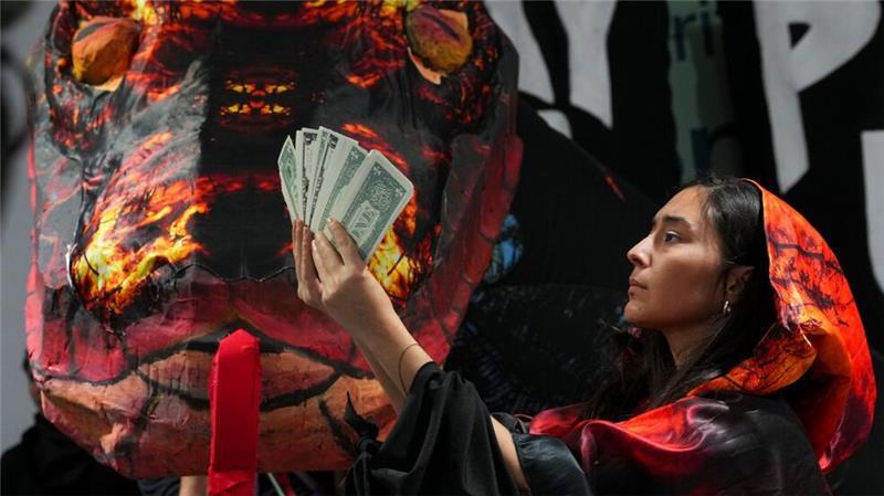 Kampf ums Geld - Der UN-Klimagipfel steht auf der Kippe Die Schlange als Symbol der gierigen Fossilindustrie bei einer Protestaktion von Klimaaktivisten in Baku.