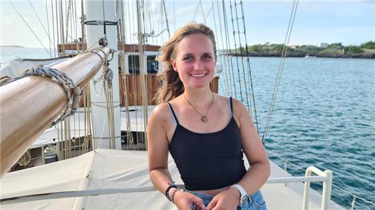 Hanmari Witte steht mit kurzem Top und wehenden Haaren an Deck des Großseglers
