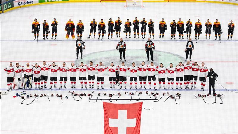 Die Schweizer (unten) und das deutsche Team steht auf dem Eis.
