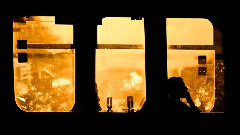 Die Silhouetten von Fahrgästen in einer Stadtbahn der Hannoverschen Verkehrsbetriebe Uestra zeichnen sich im Gegenlicht der aufgehenden Sonne ab.
