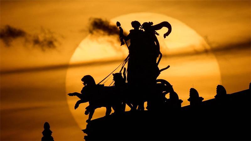 Die Sonne geht am Abend hinter der Pantherquadriga der Semperoper in Dresden unter. 