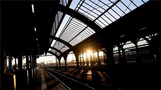 Die Sonne geht am Morgen hinter der historischen Gleishalle am Hauptbahnhof auf.