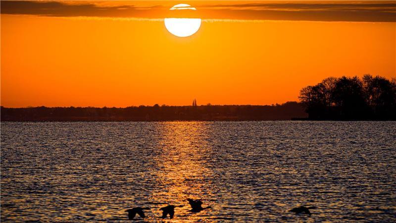 Die Sonne geht am Steinhuder Meer in der Region Hannover auf.