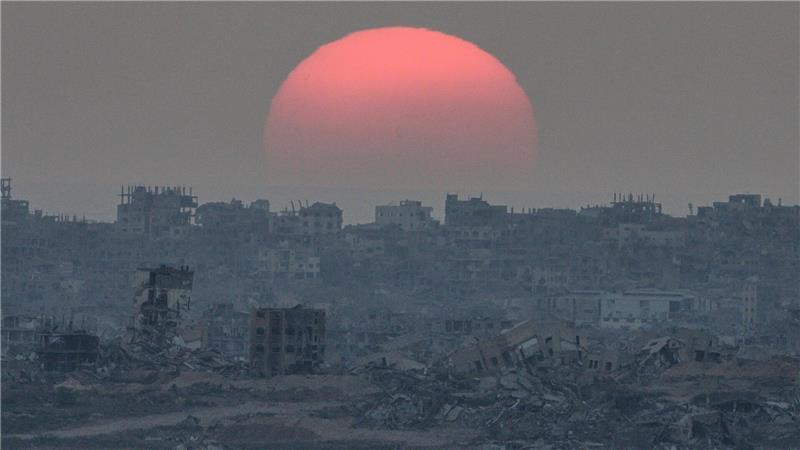 Bilder des Tages Die Sonne geht hinter Gebäuden unter, die bei israelischen Boden- und Luftangriffen im Gazastreifen zerstört wurden, gesehen vom Süden Israels aus.