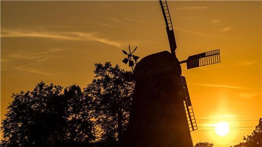 Die Sonne geht hinter der Turmholländermühle in Dörrwalde unter. 
