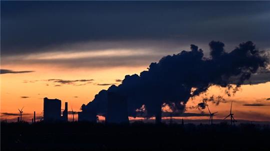 Die Sonne ist hinter dem Braunkohlekraftwerk Niederaußem in NRW untergegangen.