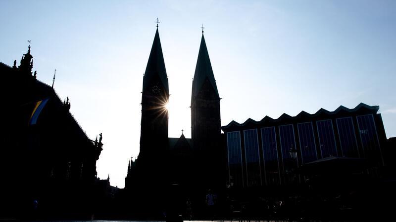 Die Sonne scheint hinter den Türmen des Sankt-Petri-Doms am Bremer Marktplatz.