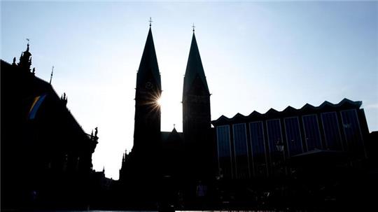 Die Sonne scheint hinter den Türmen des Sankt-Petri-Doms am Bremer Marktplatz.