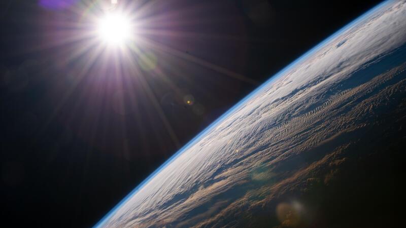 Die Sonne scheint über dem Horizont der Erde, während die Internationale Raumstation über der kanadischen Provinz Quebec kreist. Foto: NASA/dpa