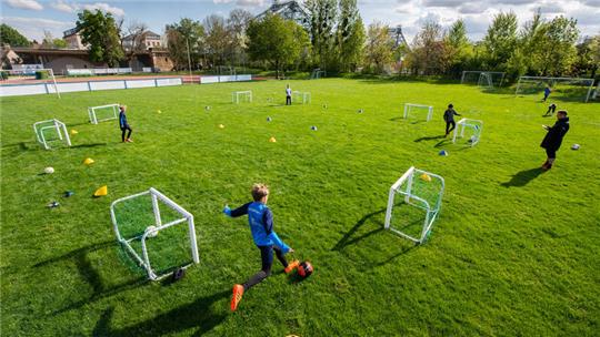 Fußballer der Altersklasse U-10 vom SV Loschwitz trainieren auf dem Spielfeld in großen Abständen.