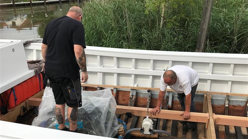 Restauriert bei Hatecke: Zwei Männer retten das größte Börteboot No.5 Die Stunde der Wahrheit: Bootsbauer Rainer Hatecke und Eigner Knud Müller (links) schauen, ob sich Wasser durch die Planken drängt.