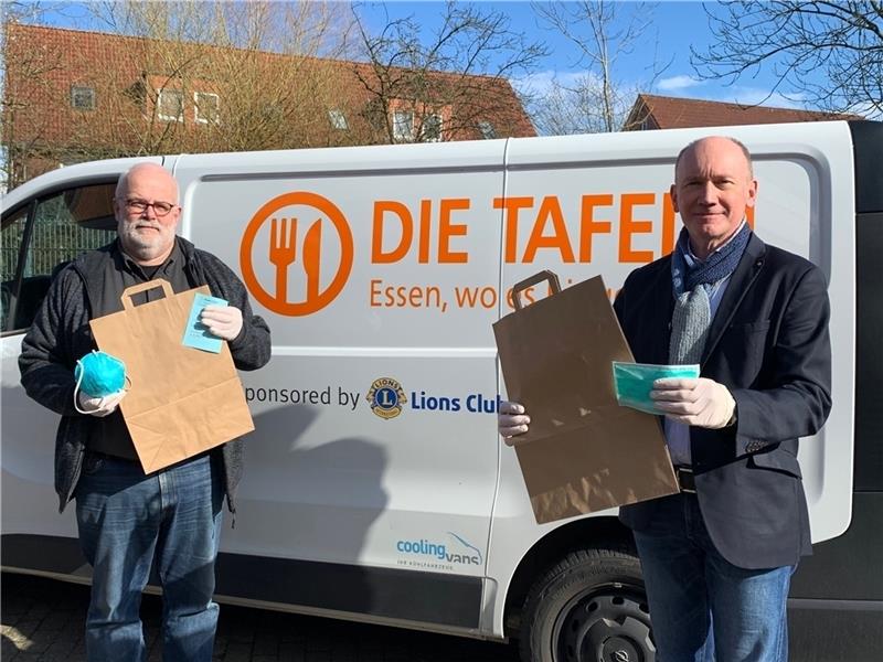 Die Tafel kehrt für die Zeit der Corona-Krise zu gepackten Tüten  zurück, wie Koordinator Timm von Borstel und Superintendent Thomas Kück hier zeigen. Schutzmasken und Handschuhe für das Personal gehören zur Ausrüstung – und waren schwer zu