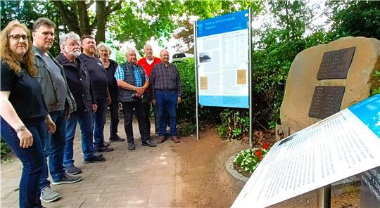 Die Tafel steht: Debbie Bülau mit Ernst-Wilhelm Cordes, Wolfgang Weh, Frank Bartels, Michael Quelle, Reiner Klintworth, Hans-Ulrich Schumacher und Frank Hoferichter am Gedenkort.