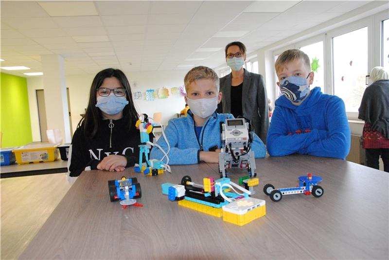 Die Technik mit Lego erkunden macht Spaß – finden Hanna-Yani, Maxim und Tjarek. Im Hintergrund Ute Pieper, Schulleiterin der Realschule Pro MINT an der Stader Privatschule. Foto: Stief