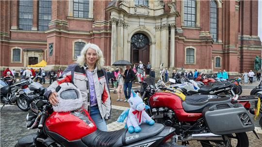 Die Teilnehmerin Christin Bliedung steht mit ihrer Suzuki 650, einem Einhorn und ihrem Panda-Helm nach dem Mogo Hamburg (Hamburger Motorradgottesdienst) vor dem Michel.