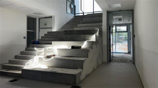 Die Treppe ins Obergeschoss ist ein Hingucker und zugleich Lerntreppe, Aufenthaltsort, Sitzmöbel oder kleine Tribüne.