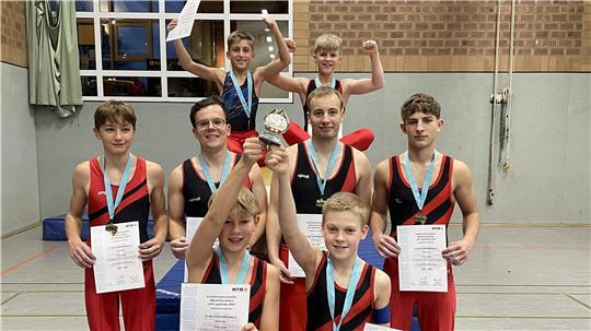 Die TuS-Turner feiern den Titel: Gustav Bröker, Marcel Wezik (vorne v.l.), Tjark Wendt, Janik de Brabandt, Lars Pätow, Bogdan Hinkel (Mitte v.l.) sowie Nikola Ignatow und Mykola Husiev (hinten v.l.).