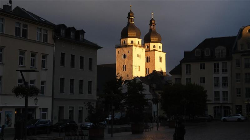 Die Türme der Johanniskirche in Plauen werden von der untergehenden Sonne beschienen.