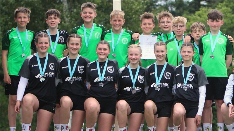 Die U14-Mädchen des MTV Wangersen hocken in einer Reihe auf einem Podium, dahinter stehen die U14-Jungs des TSV Essel in einer Reihe.