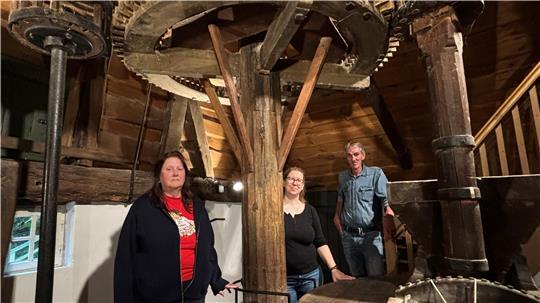 Die Vereinsvorsitzende Ilse Bach (von links), Denkmalschützerin Casha Ipach und Rüdiger Drees (Grundstücks- und Gebäudebewirtschaftung) am Mahlwerk der Wassermühle Ovelgönne. Das Mahlwerk war besonders von Holzwürmern befallen.