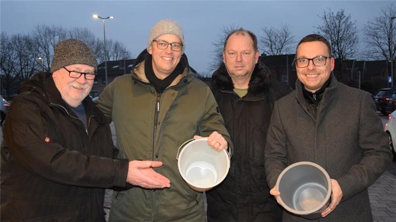 Die Verkäufer (von links) Wilfried Peters, Knut Willenbockel, Ralf Kimmel und Marko Bergmann zeigen gegen 9 Uhr vor Edeka Drewes in Horneburg die leeren Eimer: alle Glücksschweine verkauft.