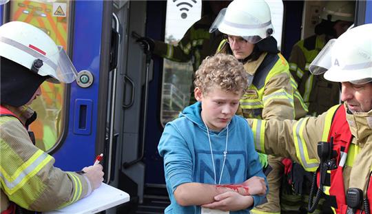 Die "Verletzten" werden ins Freie gebracht. Geschminkte Nachwuchsfeuerwehrleute und DRK-Mitglieder mimen die verletzten Fahrgäste im "Start"-Zug nach einem simulierten Zusammenstoß mit einem Kesselwagen bei einer Alarmübung. Fotos: Feuerwehr