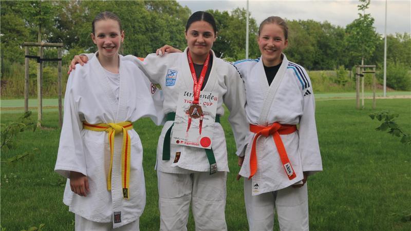 VfL-Judoka beim Tiger Cup: Nur eine Staderin landet auf dem Treppchen Die Judoka Julia Schramm, Nicole Schrej und Josie Schmidt Petersen stehen nebeneinander im Schulterschluss und tragen weiße Judo-Mäntel.