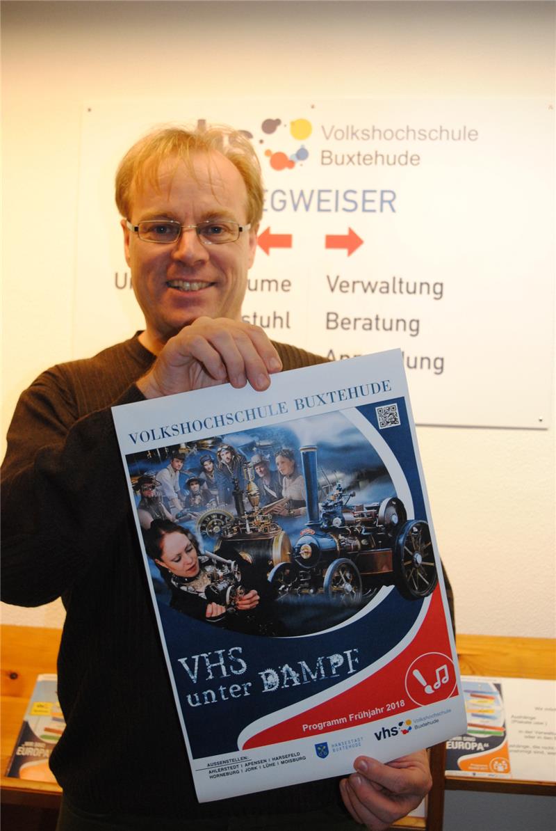 Die Volkshochschule Buxtehude steht weiterhin unter Dampf: VHS-Leiter Dr. Dirk Pohl präsentiert das Plakat für das neue Semester. Rund 600 Kurse sind im Angebot – auch für das Steampunk-Festival im April. Foto: Vasel