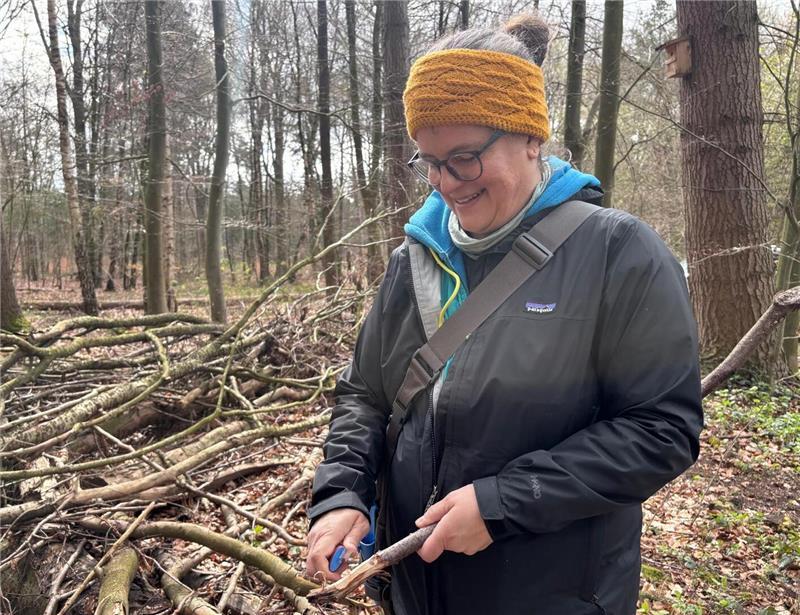 Die Waldpädagogin Carolin Schmiech beim Schnitzen eines Astes. Hieraus könnten etwa Pfeil und Bogen entstehen.
