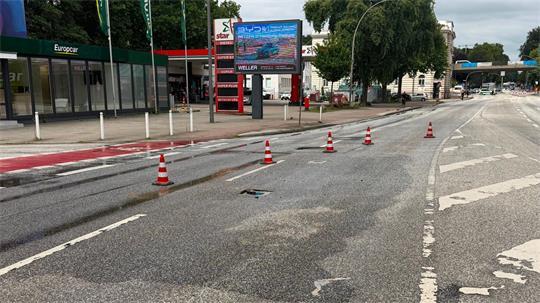 Die Wasserflecken sind auf der Fahrbahn gut zu erkennen. Die Buxtehuder Straße wurde am Vormittag gesperrt. Mittlerweile sind zwei Spuren wieder freigegeben.