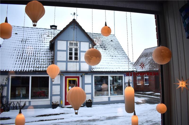 Weltkugel, Mond, Heißluftballon und weitere Mini-Lampen leuchten und hängen im Schaufenster.