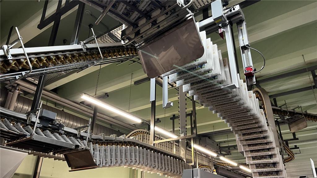 Die Zeitungen werden per Förderband in die Versandhalle geschickt.