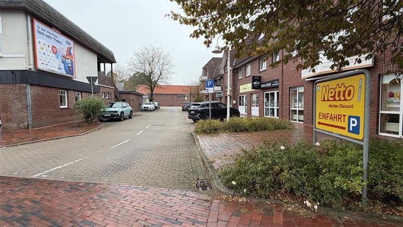Vollsperrung des Kreisels in Apensen: Was Autofahrer wissen müssen Die Zufahrt von der Buxtehuder Straße zwischen Kreuzfahrtlounge (links) und Teig und Zeug (rechts) führt zum Parkplatz auf dem Roten Platz.