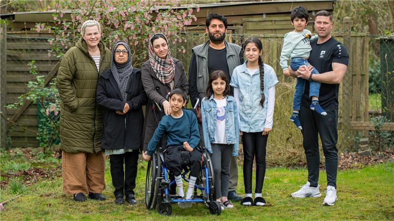 Bezahlbare Wohnung fehlt: Findet Osmans Familie ein neues Zuhause? Die afghanische Familie Hashemi hofft auf ein neues Zuhause in Schiffdorf (von links) Nicole Mimouna, Gulrukh, Sara, Moez Hashemi (im Rollstuhl), Vater Said Hashemi, die Töchter Benazir und Hasanat sowie Marc Krüger mit Osman auf dem Arm.