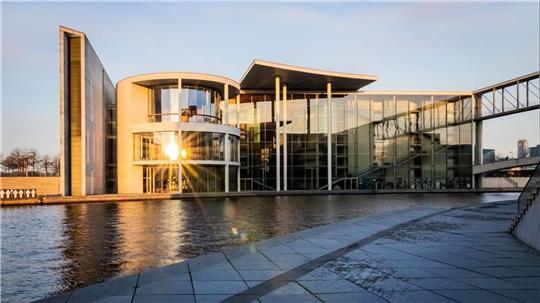 Die aufgehende Sonne spiegelt sich im Paul-Löbe-Haus des Deutschen Bundestag.