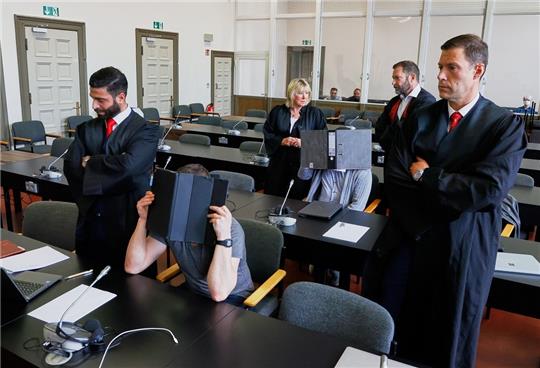 Die beiden Angeklagten sitzen umringt von ihren Verteidigern, den Rechtsanwälten Aslan Taheri (l-r), Astrid Denecke, Daniel Scheibner und Christian Lödden, vor Prozessbeginn im Gerichtssaal. Die beiden Angeklagten sollen mit Komplizen 2019 und 2020 Kokain in größeren Mengen aus Südamerika über den Hamburger Hafen geschmuggelt und mit beteiligten Lkw-Fahrern aus dem Hafen gebracht haben. Foto: Georg Wendt/dpa